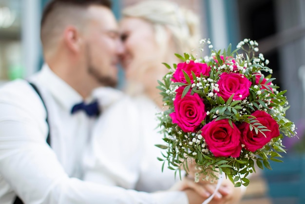 Ramo de novia en el fondo de una pareja besándose borrosa Flores y amantes