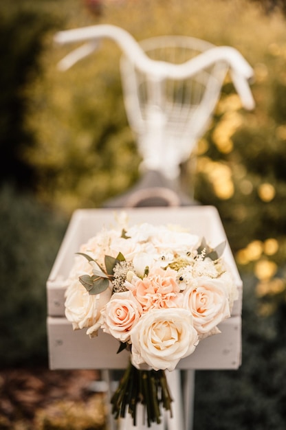 Ramo de novia fuera de la novia con un vestido beige sostiene las flores ramo de flores y vegetación