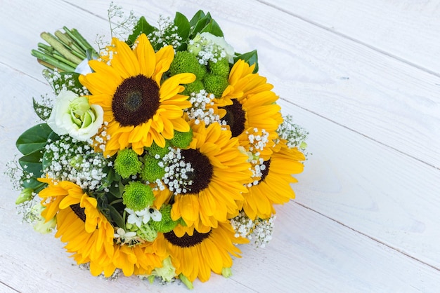 Ramo de novia de girasol sobre un fondo de madera Vista superior con espacio de copia