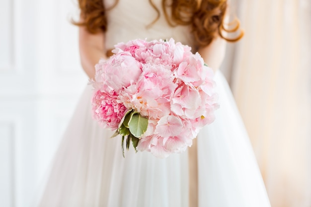 Ramo de novia Hermoso de flores de color rosa de la boda en manos de la novia.