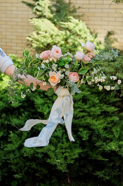 Ramo de novia en manos de la novia, david austin rose, fondo verde