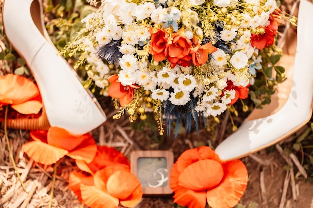 Foto ramo de novia de la novia con anillos y zapatos para una boda fotografiada en la naturaleza