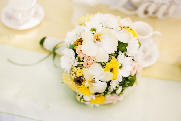 Ramo de novia de orquídeas blancas y rosas amarillas