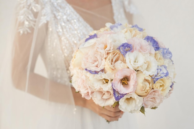 Ramo de novia de primer plano con eustoma y flores de peonía en manos nupciales