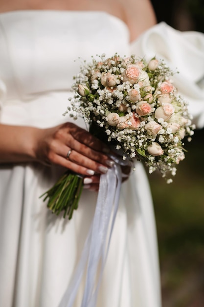 Ramo de novia de rosas blancas en manos de la novia