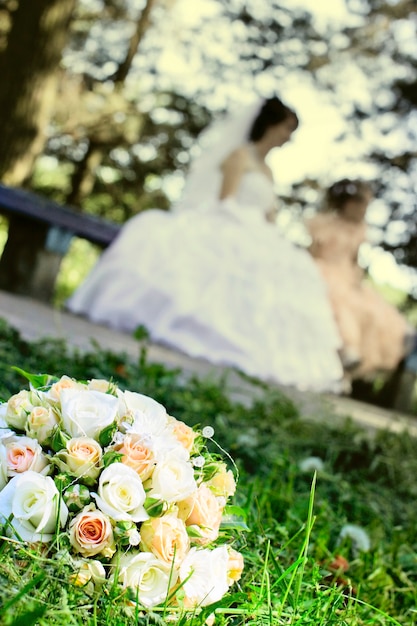 Ramo de novia con rosas blancas recostada sobre el césped