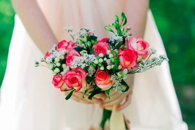 Ramo de novia de rosas blancas y rojas en manos de la novia