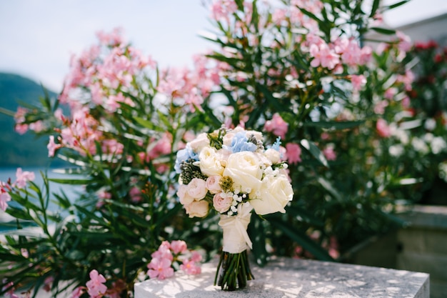 Foto ramo de novia de rosas blancas y rosas bebés respiran scabiosa hortense y cintas blancas cerca del