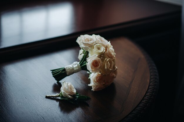 Ramo de novia con rosas y flor en el ojal. La decoración de la boda.