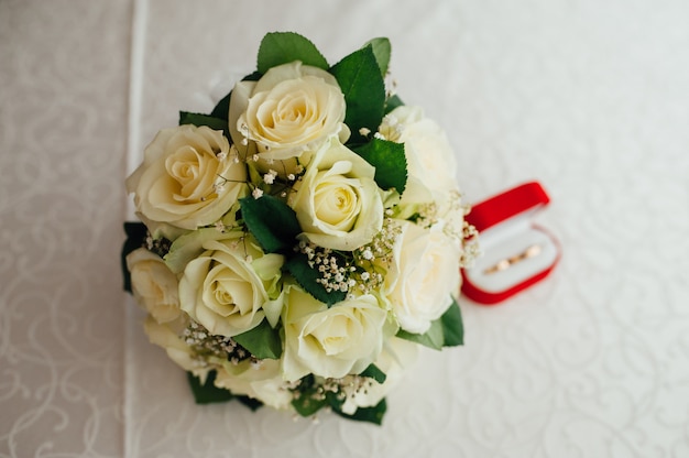 Ramo de novia con rosas de pie en una ventana