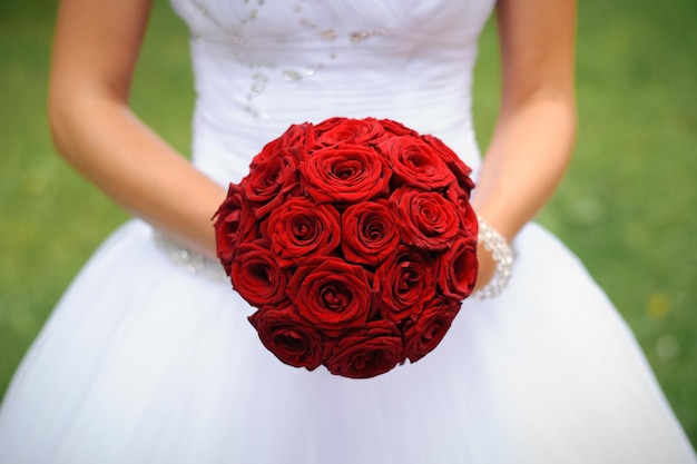 Ramo de novia de rosas rojas en manos de la novia