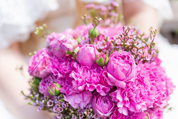 Ramo de novia con rosas rosas y lilas. Composición floral tradicional para ceremonia de boda.