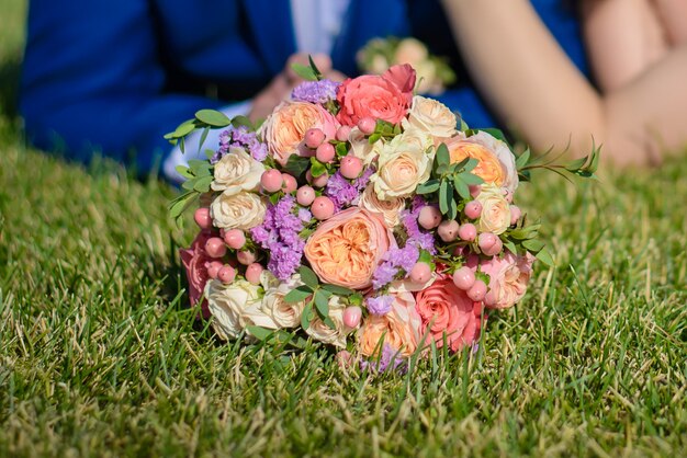 Ramo de novia sobre la hierba a los novios