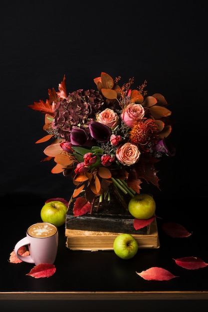 Ramo de otoño colorido. Composición de otoño con capuchino caliente, libros, rosas, tulipanes, hojas secas y hierbas.