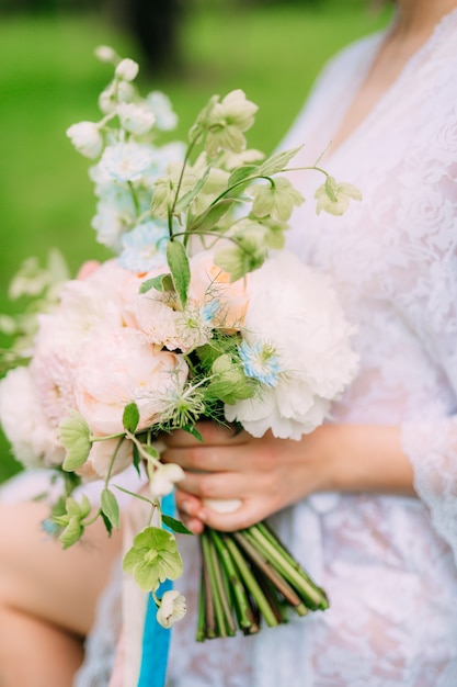 Ramo de peonías en manos de la novia en la boda