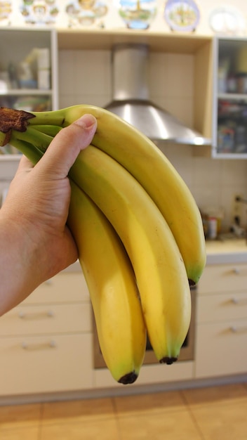 Un ramo de plátanos maduros en humanos y contrata una foto de stock