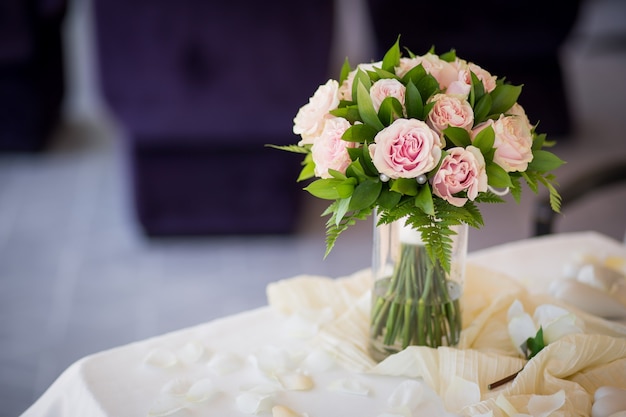 Ramo romántico de boda de rosas rosadas con verde sobre la mesa. Ceremonia de matrimonio