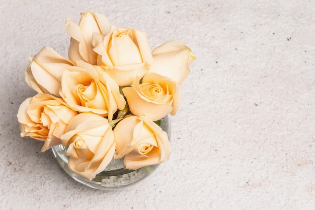 Ramo de rosas beige frescas en un jarrón. El concepto festivo para bodas, cumpleaños, 8 de marzo, día de la madre o San Valentín. Tarjeta de felicitación, fondo claro