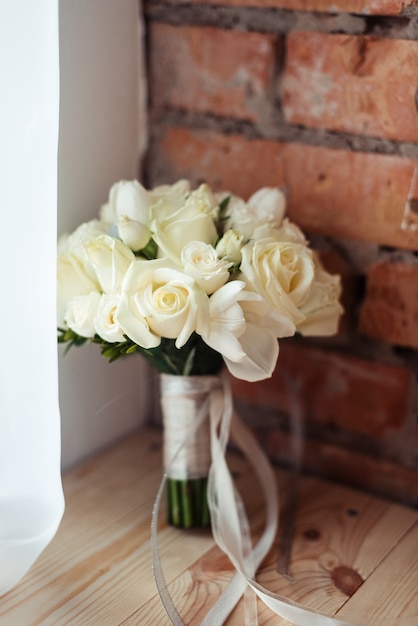 Ramo de rosas blancas en un espacio de pared de ladrillo