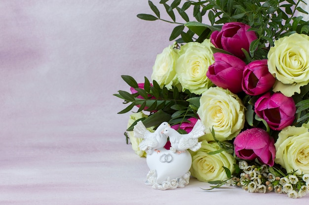 Ramo de rosas blancas y tulipanes rosados y dos palomas blancas en el corazón