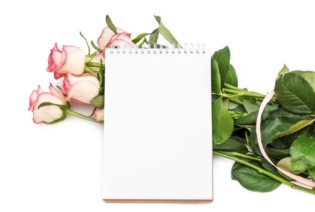 Ramo de rosas con bloc de notas en blanco sobre blanco