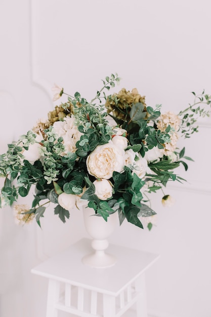 Ramo de rosas en un interior blanco en detalles de boda de pared blanca