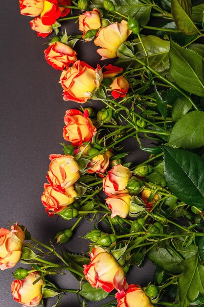 Ramo de rosas naranjas brillantes sobre fondo de piedra negra.