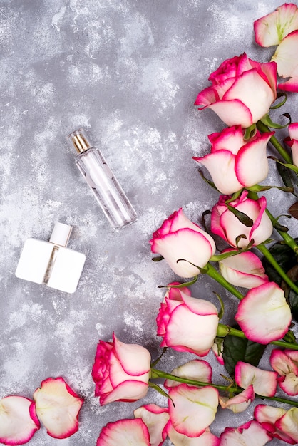 Ramo de rosas con perfume sobre un fondo gris con espacio de copia