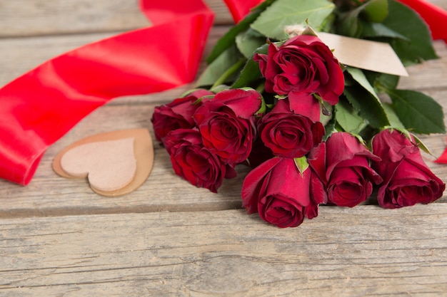 Foto ramo de rosas rojas rodeadas de decoración en forma de corazón