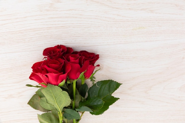 Ramo de rosas rojas sobre fondo de madera. romance flor primavera verano naturaleza frescura copia espacio.