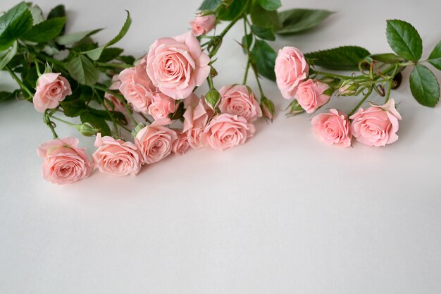 Ramo de rosas rosa pálido en mesa de luz