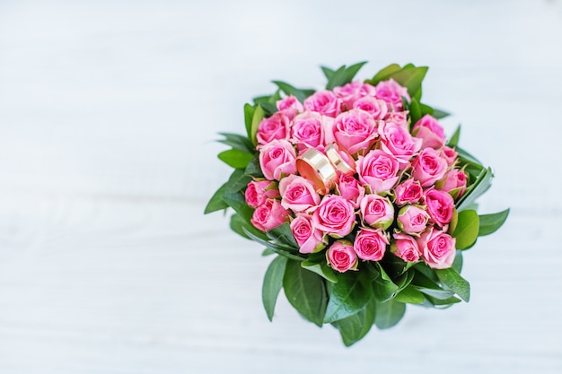 Ramo de rosas rosadas y anillos de boda. Copia espacio El concepto