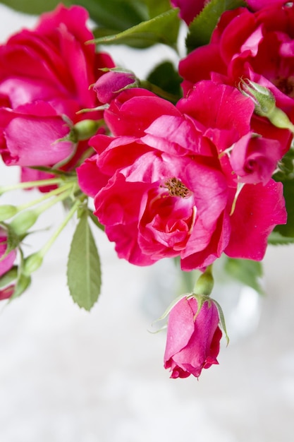 Ramo de rosas rosadas en un jarrón transparente sobre un fondo de madera para el Día de la Madre