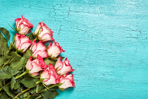 Ramo de rosas rosadas en madera azul.