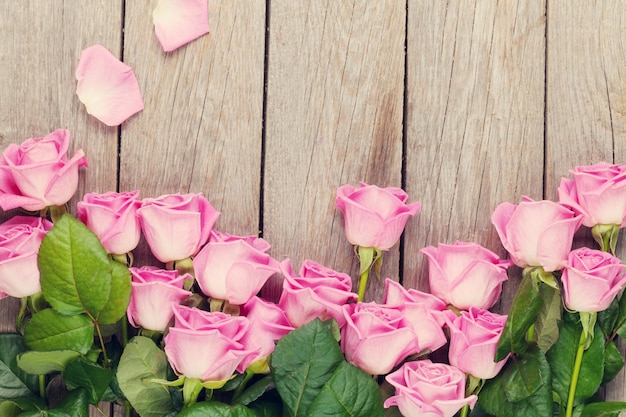 Ramo de rosas rosadas sobre mesa de madera