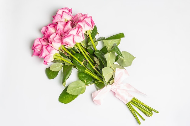 Un ramo de rosas rosadas suaves aislado en superficie blanca