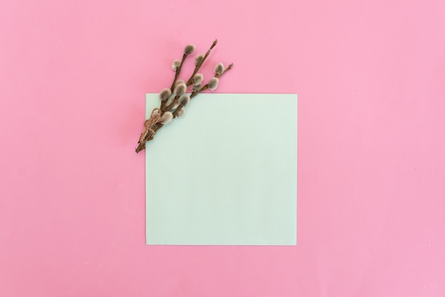 Ramo de rosas tiernas con una tarjeta de felicitación en blanco y un sobre en el fondo de madera rústico blanco