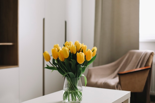 Ramo de tulipanes amarillos frescos sobre una mesa en el interior de la sala de estar