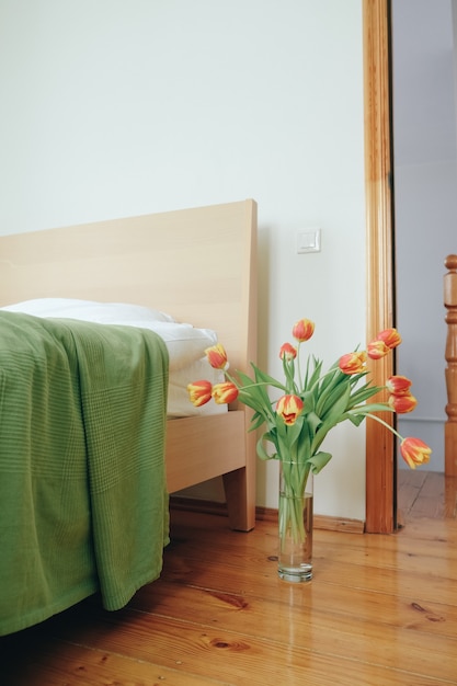 Ramo de tulipanes amarillos rojos en un dormitorio en el fondo de la cama. Concepto de amor