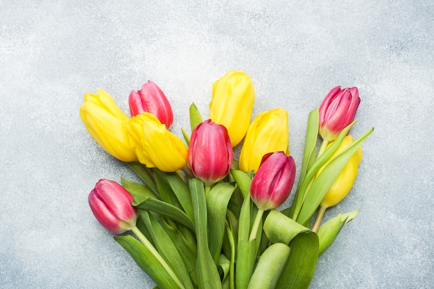 Ramo de tulipanes amarillos y rosados en un azul claro. copyspace