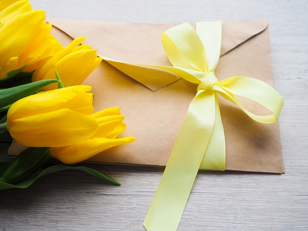 Ramo de tulipanes amarillos con sobre, atado con un espacio de cinta para el texto