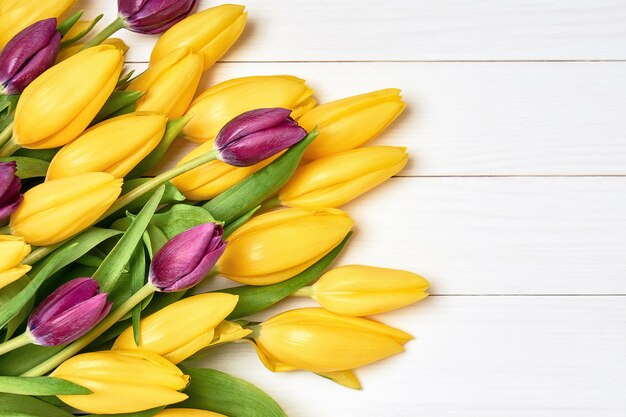 Ramo de tulipanes amarillos sobre fondo blanco de madera. Ramo. Copie el espacio, vista superior.