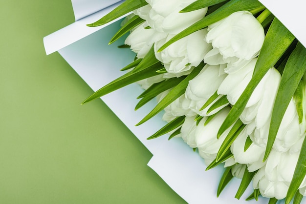 Foto un ramo de tulipanes blancos sobre un fondo verde pastel con flores en flor concepto festivo