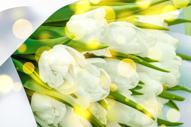 Un ramo de tulipanes blancos sobre un fondo verde pastel con flores en flor concepto festivo