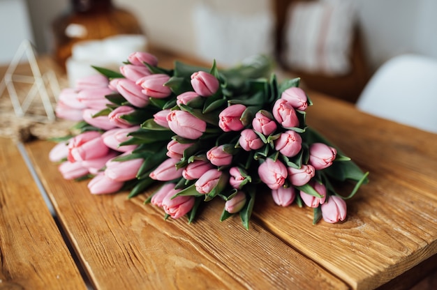 Ramo de tulipanes en diseño de borde de mesa de madera