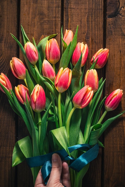 Foto un ramo de tulipanes se encuentra sobre un fondo de madera marrón