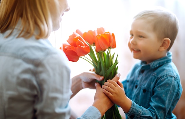 Ramo de tulipanes para mamá Hijo pequeño felicita a mamá y le regala un ramo de tulipanes Madre feliz ...