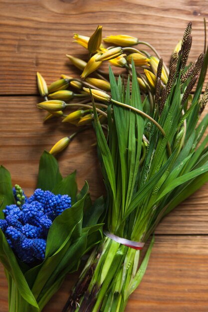 Ramo de tulipanes y muscari en mesa. Primer plano de fondo de flores, primavera colorida, mañana brillante, concepto de naturaleza