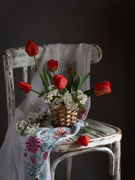 Ramo de tulipanes rojos en florero de madera en cher vintage. Día de San Valentín, día de la madre, concepto de cumpleaños.