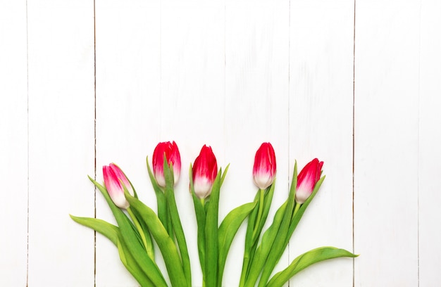 Ramo de tulipanes rosados en un fondo de madera rústico blanco